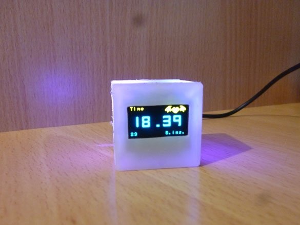 Et lille sødt ur med baggrundsbelysning og et termometer